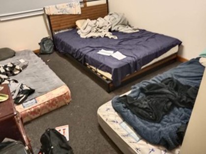 Overcrowded bedrooms, with men and women sleeping on mattresses on the floor
